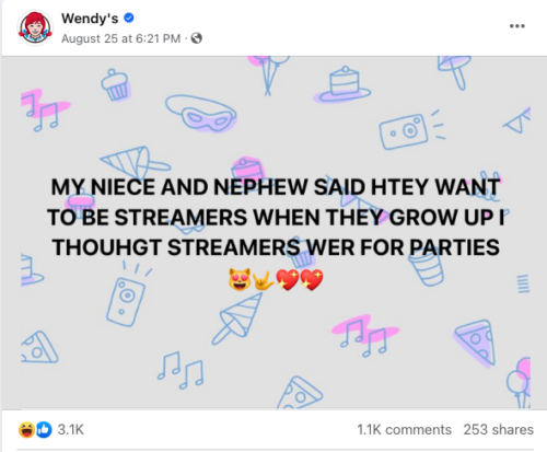 A post from Wendy’s Facebook page. The post is a background with various cartoon items, such as party hats, pizza slices and musical notes. The text overlay says “MY NIECE AND NEPHEW SAID HTEY WANT TO BE STREAMERS WHEN THEY GROW UP I THOUHGT STREAMERS WER FOR PARTIES”. (The spelling errors are deliberate.) 