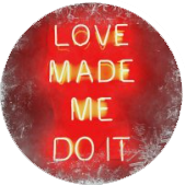 Circular red neon sign reading 'LOVE MADE ME DO IT.'